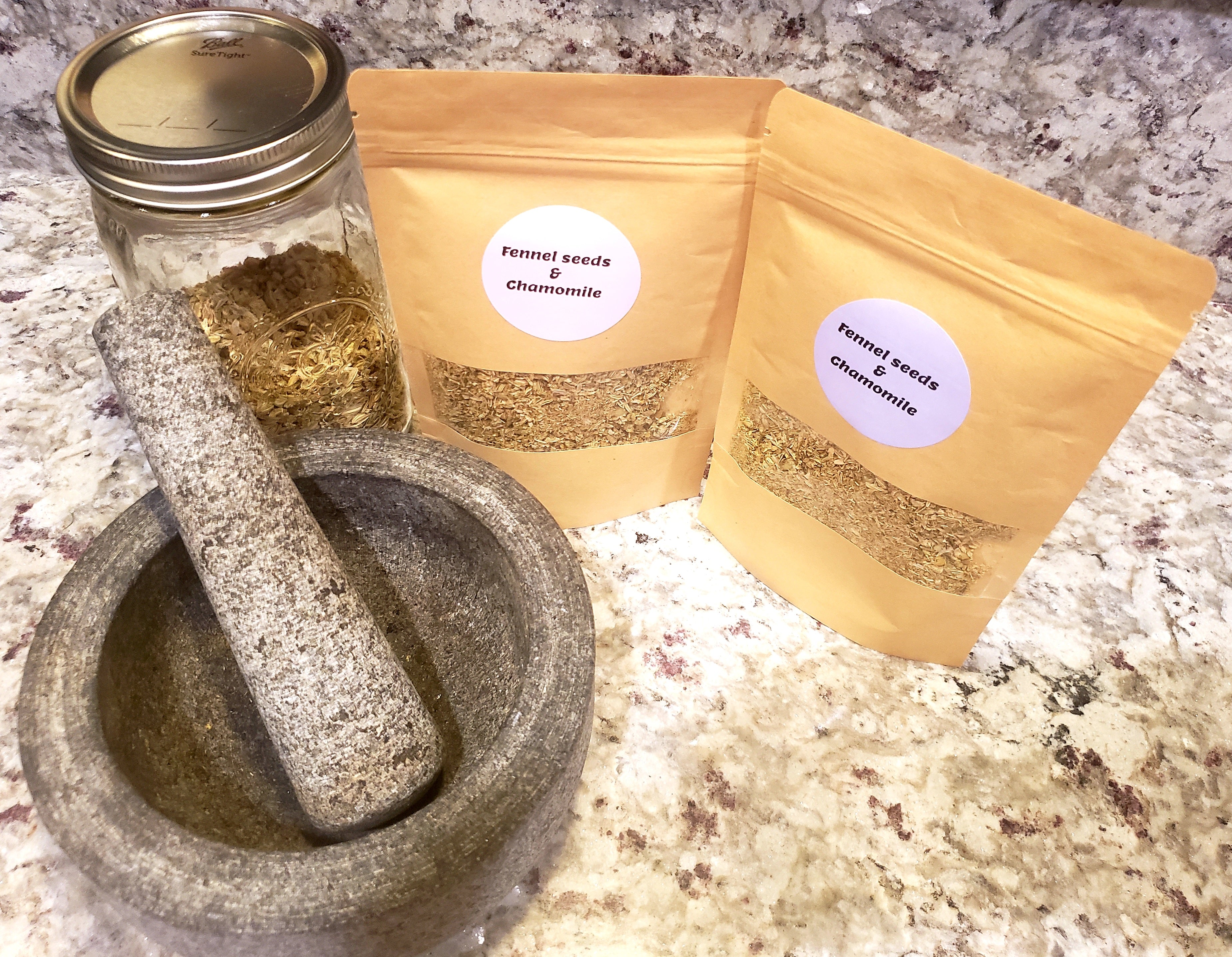 Organic fennel seed and chamomile herbal tea by Tincture Treasures in a clear glass cup showing loose tea leaves and herbs.